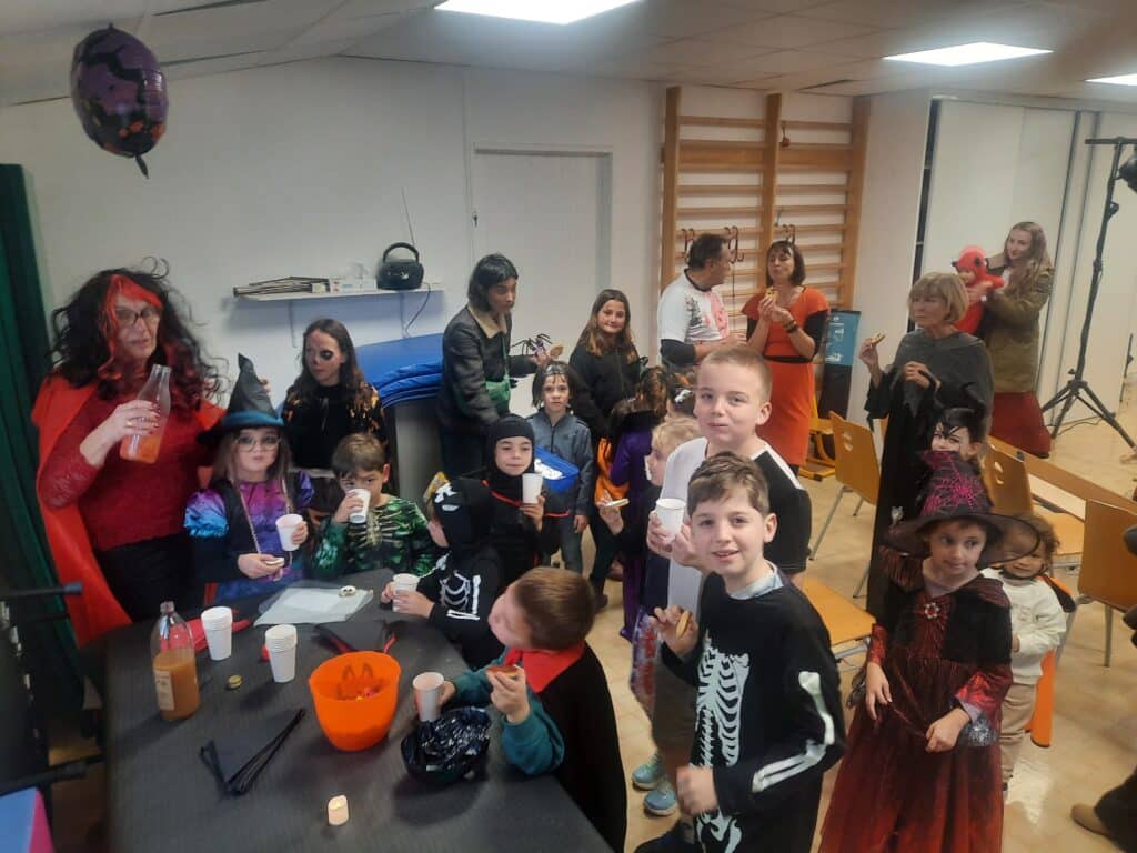 Enfants, parents et bénévoles profitent du goûter et des boissons d’Halloween