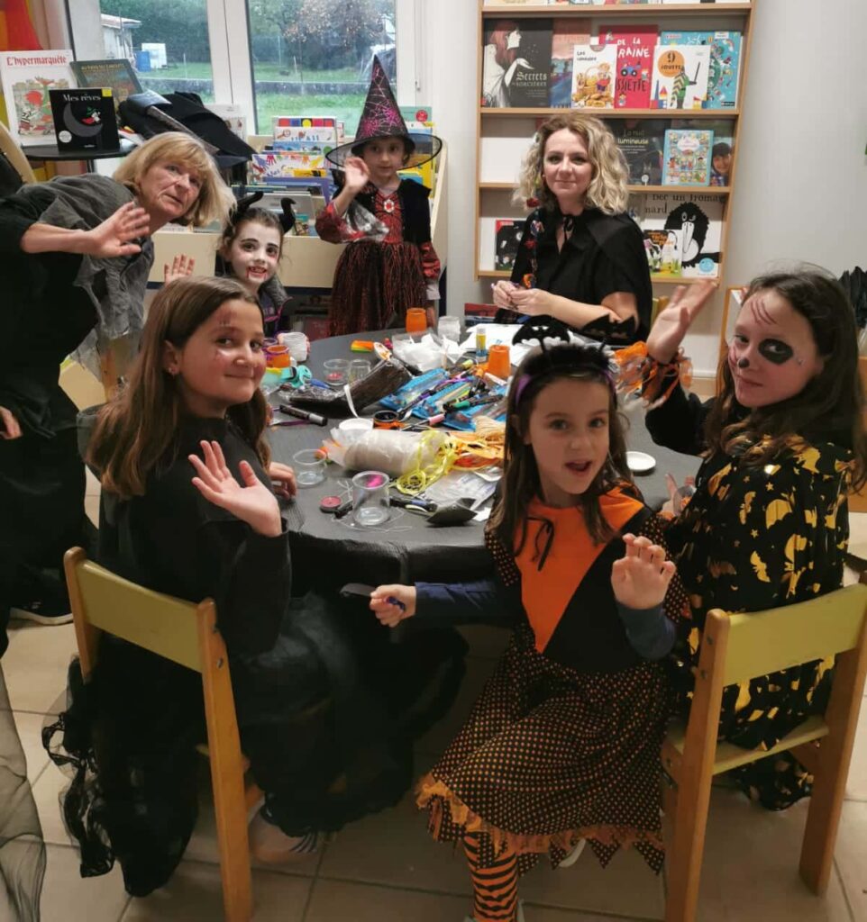 Groupe d’enfants et de bénévoles assis réalisant des activités manuelles