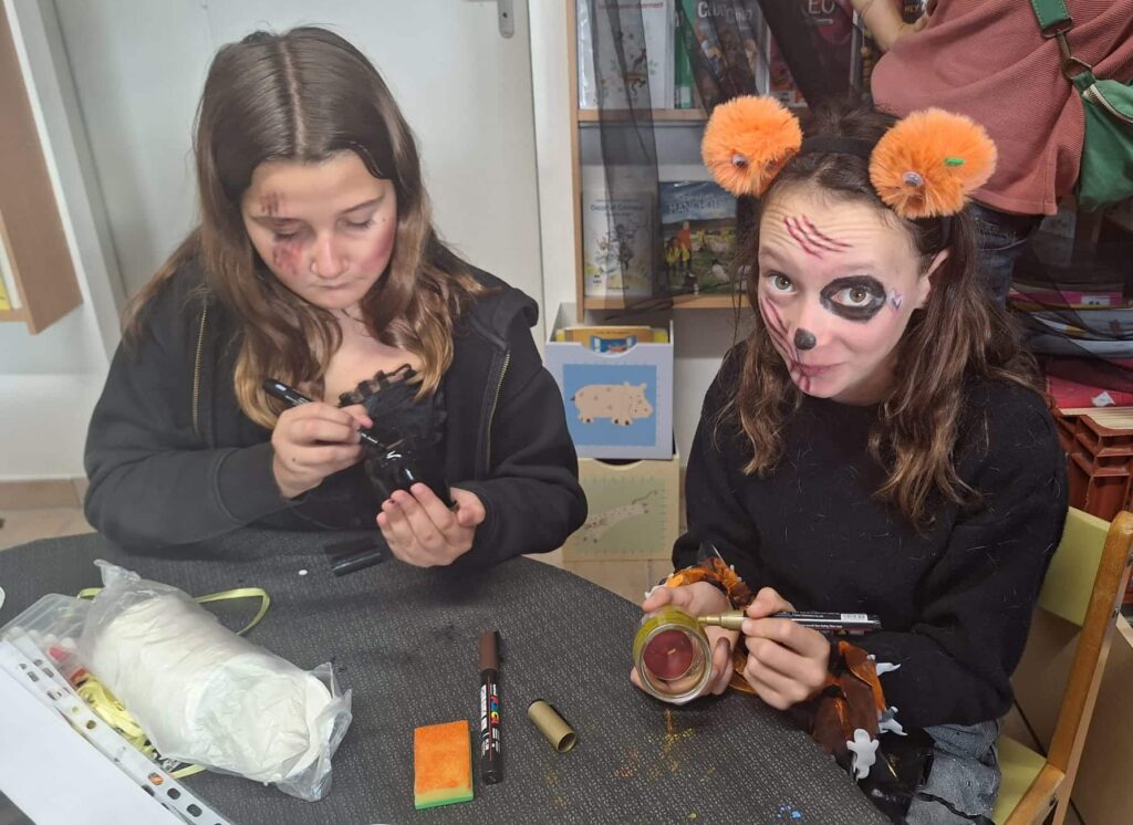 Deux jeunes filles déguisées fabriquent des lanternes d’Halloween